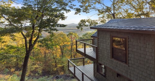 side view of a virginia treehouse with lots of yellow and green trees in the background
