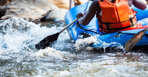 Close-up of young person rafting on the river, extreme and fun sport at tourist attraction