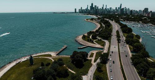 A highway next to a lake with a city skyline in the background.