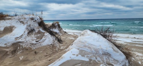 Snow tops sand dunes along the shores of Lake Michigan