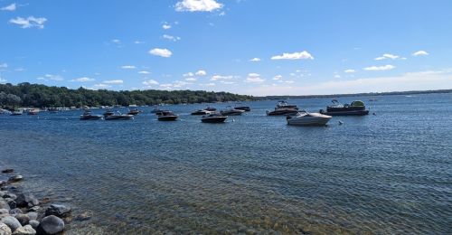Multiple small boats are anchored in a lake.
