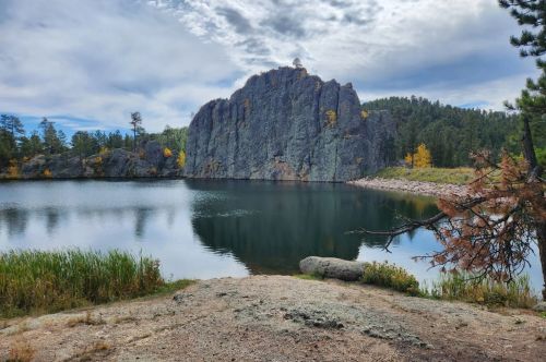 A view of a lake with needle-like rock formations above it.