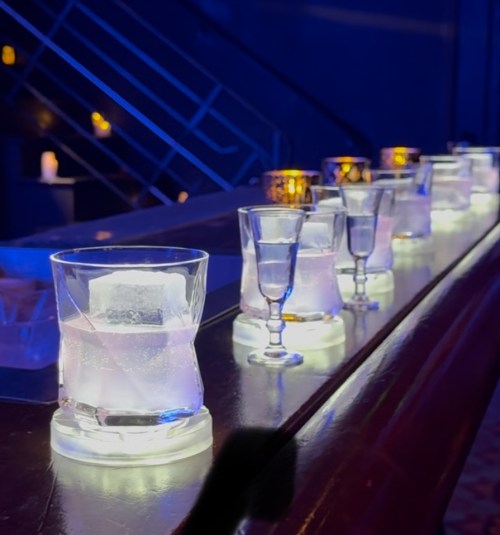 Drinks set on bar with ice cubes