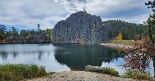 A view of a lake with needle-like rock formations above it.
