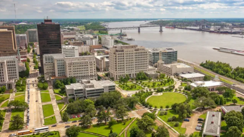 Aerial view of a city with business district along the river under a blue sky with clounds
