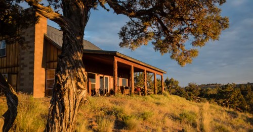 The exterior of a rustic cabin Airbnb in Oregon, perched on top of a hill.