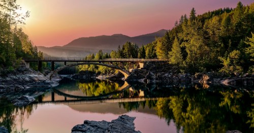 A sunrise across Belton Bridge over Middle Fork Flathead River near West Glacier in Glacier National Park, Montana, USA