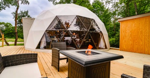 A fire pit next to a geo dome Airbnb in Pennsylvania