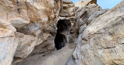 a large rock formation cave with a hole in the middle