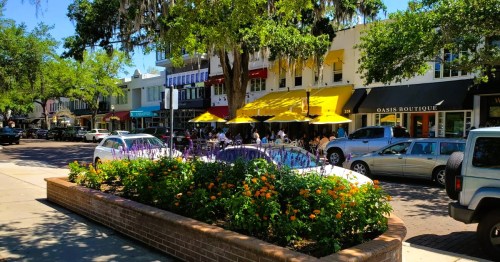 Views of Winter Park, a hidden gem town near Orlando, Florida, featuring sidewalk planters and a street lined with restaurants and adorable shops