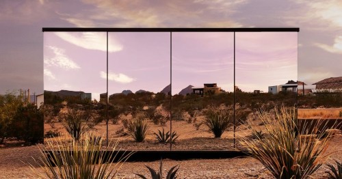 four panels of mirrors on the exterior of a cabin in the middle of big bend national park with purple-grey skies and a desert oasis