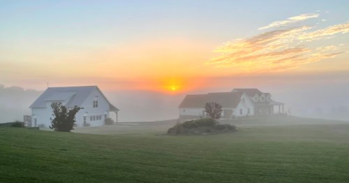 Morning fog surrounds a an Airbnb in Missouri at sunrise.