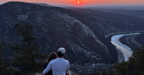 A couple enjoys the sunset view from a hiking trail in New Jersey.