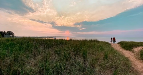 Two people wander down a sandy trail to Corny Beach in Wisconsin.