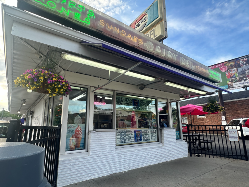 Dairy Del exterior with white brick, pick up windows, and a neon sign