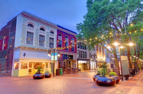 The downtown mall in Charlottesville, Virginia, featuring a pedestrian walkway lit with twinkle lights and quaint storefronts.