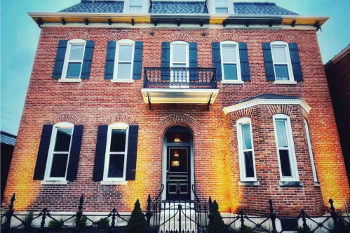 The welcoming exterior of a historic brick home with many windows.