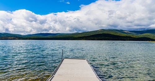 A fishing pier extends out onto the blue water of Lake Mary Ronan in northern Montana.