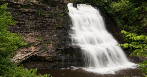 Muddy Creek Falls in Maryland’s Swallow Falls State Park, showing rushing water over rocky cliffs and lush greenery.