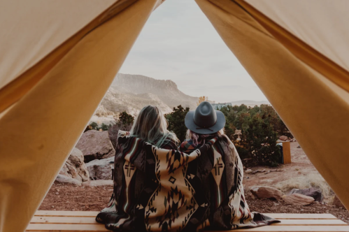 Two women share a blanket gazing at the sunset