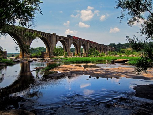 Gorgeous views of the James River Bridge in Virginia, surrounded by a scenic river with exposed boulders.