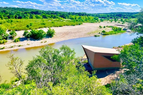 A glamping tent overlooking a picturesque river at the best waterfront campground in Texas.