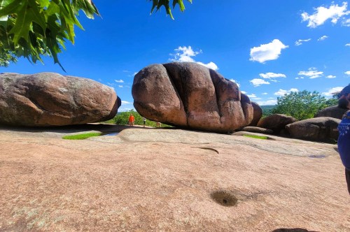 Large boulders along a hiking trail inside Elephant Rock State Park, with several visitors posing for pics between the rocks.
