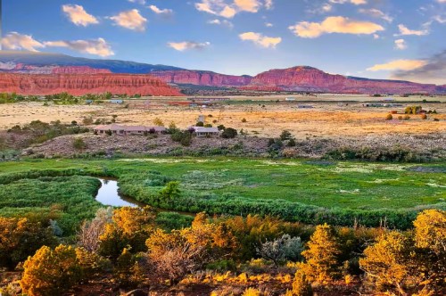 A waterfront Airbnb in Utah with a scenic fishing spot, featuring stunning views of the red rock cliffs in the distance.