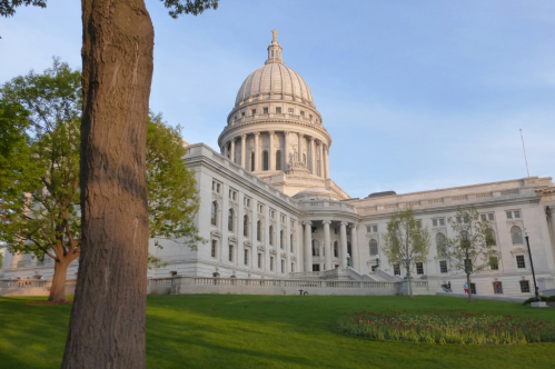 The Wisconsin State Capitol Building during the daytime with a very green lawn