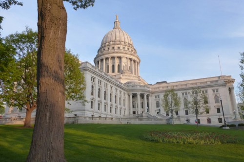The Wisconsin State Capitol Building during the daytime with a very green lawn