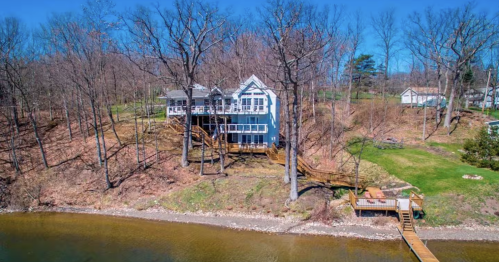 a large blue house on the lake