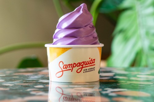 Cup of purple ube soft serve ice cream on a table.