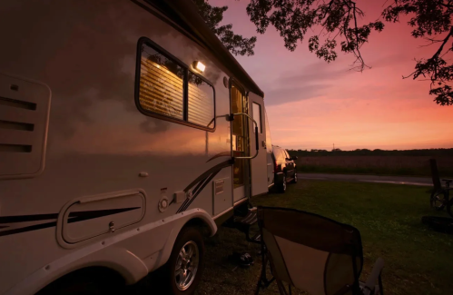 A white RV is highlighted by the pink colors of dusk.