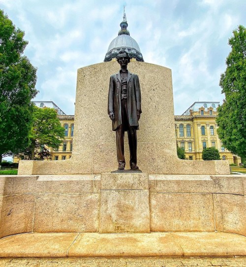A statue of President Abraham Lincoln in front of the current Illinois State Capitol Building.