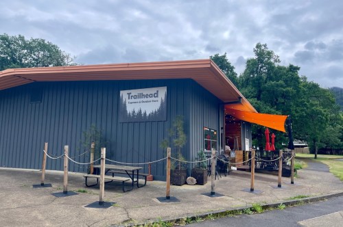A blue building with orange awnings and a sign that says "Trailhead."