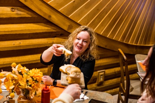 A woman taking bread from a bread board at Weatherwood Supper Club