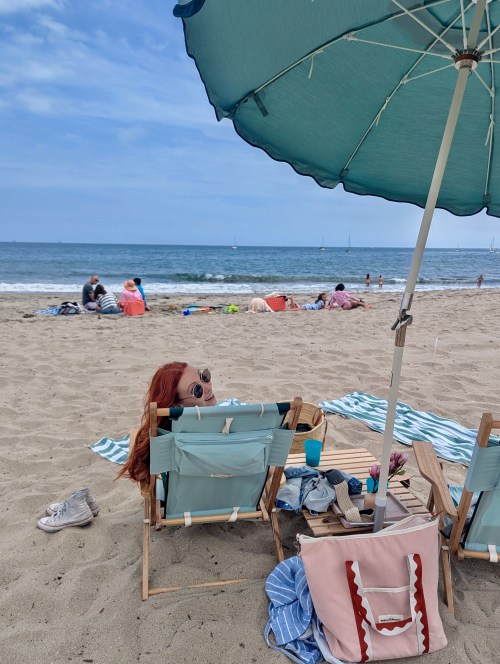 A girl sits on the beach at The Barbara