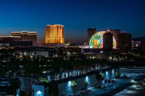 a wide shot of the north end of the Las Vegas Strip with The Venetian Las Vegas, Palazzo Las Vegas, Wynn Las Vegas, the Sphere and Encore Las Vegas seen in the distance at night
