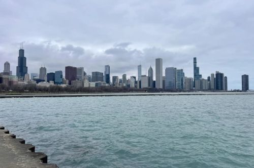 Skyline view of city buildings and a lake.