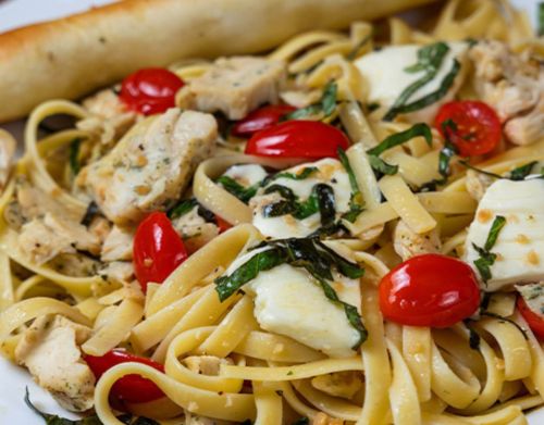 A close-up of pasta with cheese and tomatos