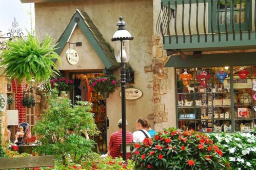 Storefront at The Village Shops in Gatlinburg, Tennessee, with flowers, ferns, and a large window