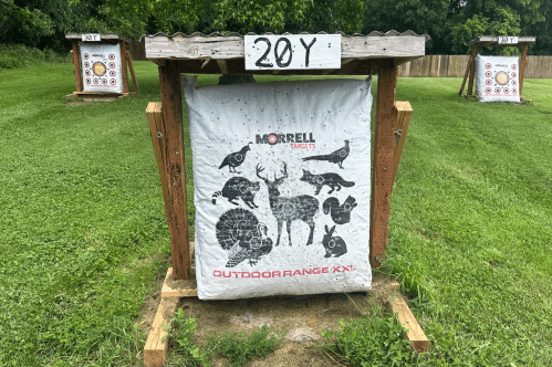 White archery sign surrounded by a wooden platform with images of animals like a turkey, a deer, and a rabbit