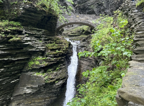 Tall waterfall underneath a stone bridge in Watkins Glen State Park