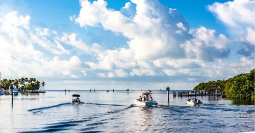 Views of boats on a scenic waterway heading to Biscayne Bay in Miami, under cloudy sky.