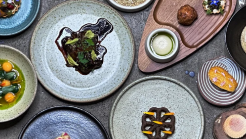 Looking down at plates of all sizes with single food items on each.