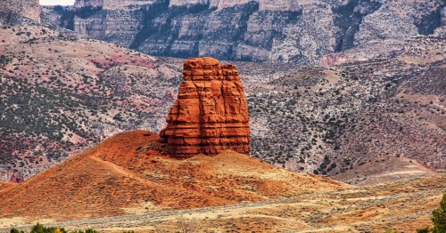 Red sandstone spire of Chimney Rock standing against the Bighorn Mountains in Shell, Wyoming.