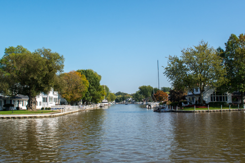 View of waterfront town in Ohio with buildings on either side under a bright blue sky