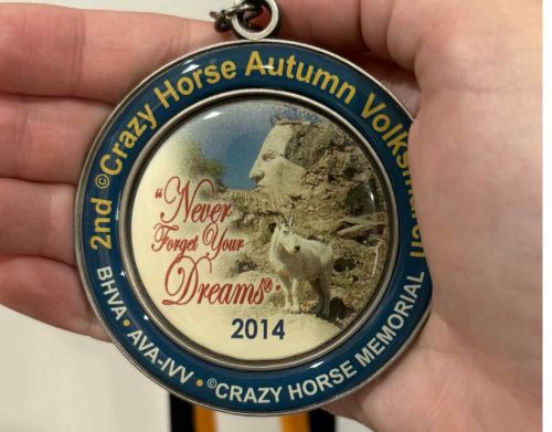 A close-up of the Crazy Horse Memorial Volksmarch participant medal.