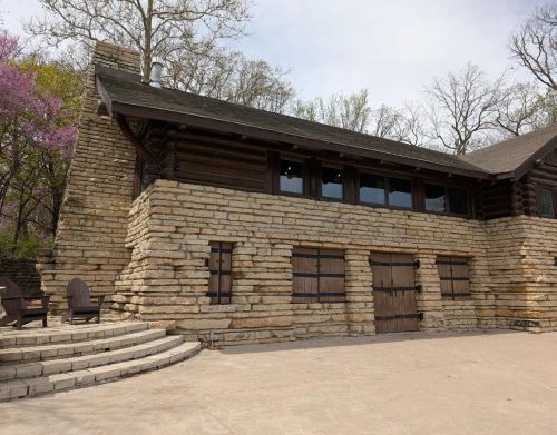 A large wooden and stone visitor center with wooden doors.