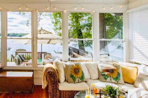 A well-lit living room overlooking a lake.
